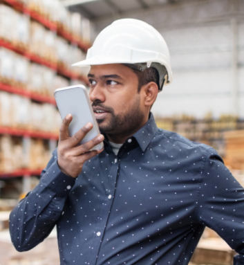 man with black beard in construction hat speaking on phone