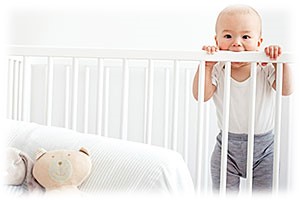 baby in a crib with mouth on rail